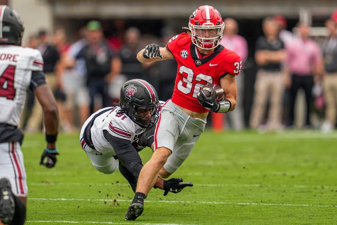 Sep 16, 2023; Athens, Georgia, USA; Georgia Bulldogs running back Cash Jones (32) runs out of a tackle by South Carolina Gamecocks defensive back Peyton Williams (31) during the first quarter at Sanford Stadium. Mandatory Credit: Dale Zanine-USA TODAY Sports