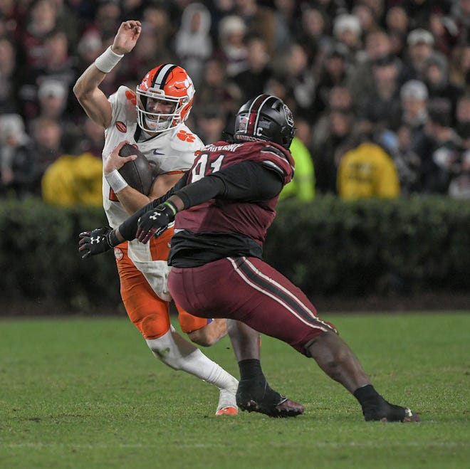 Clemson quarterback Cade Klubnik (2) runs near South Carolina defensive tackle Tonka Hemingway (91) during the fourth quarter Nov 25, 2023; Columbia, South Carolina, USA; at Williams-Brice Stadium. Clemson beat South Carolina 16-7.