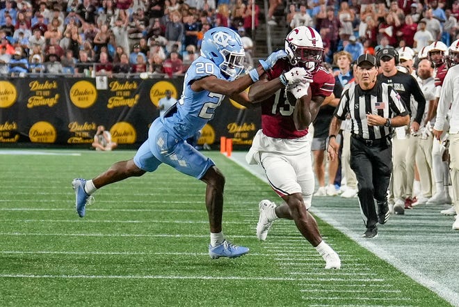 Sep 2, 2023; Charlotte, North Carolina, USA; North Carolina Tar Heels defensive back Tayon Holloway (20) tackles South Carolina Gamecocks wide receiver Payton Mangrum (13) after a pass reception during the second half at Bank of America Stadium. Mandatory Credit: Jim Dedmon-USA TODAY Sports