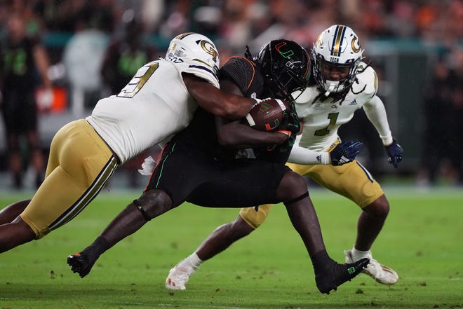 Oct 7, 2023; Miami Gardens, Florida, USA; Georgia Tech Yellow Jackets defensive lineman Kyle Kennard (9) tackles Miami Hurricanes running back Donald Chaney Jr. (2) in the first half at Hard Rock Stadium. Mandatory Credit: Jasen Vinlove-USA TODAY Sports