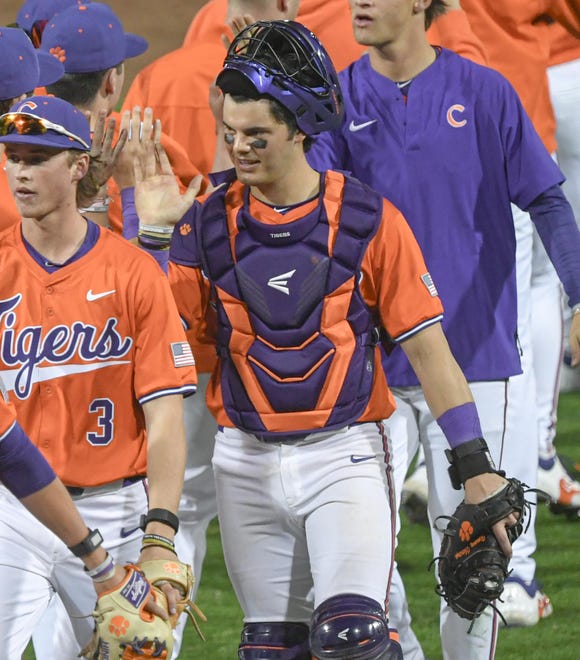 Clemson catcher Jimmy Obertop high-fives teammates after beating Xavier during practice at Doug Kingsmore Stadium in Clemson, S.C. Friday, February 16, 2024.