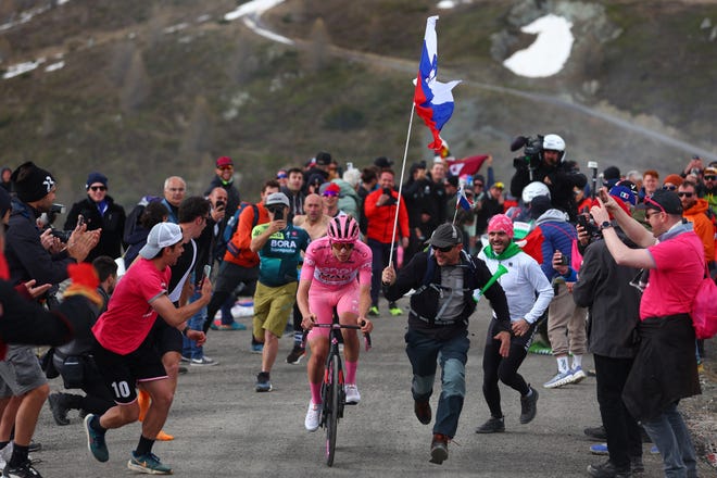 May 19, 2024: Pink jersey Team UAE's Slovenian rider Tadej Pogacar climbs surrounded by fans to win the 15th stage of the 107th Giro d'Italia cycling race, 222km between Manerba del Garda and Mottolino.