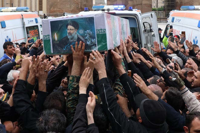 May 21, 2024: This handout picture provided by the Iranian president's office shows mourners gathering around the coffin during a funeral procession in Tabriz, the capital of Iran's East Azerbaijan province, for late president Ebrahim Raisi (portrait) and seven others killed with him in a helicopter crash two days ago. Tens of thousands of Iranians gathered in Tabriz on May 21 to mourn Raisi and seven members of his entourage who were killed in the crash on a fog-shrouded mountainside in northwestern Iran.