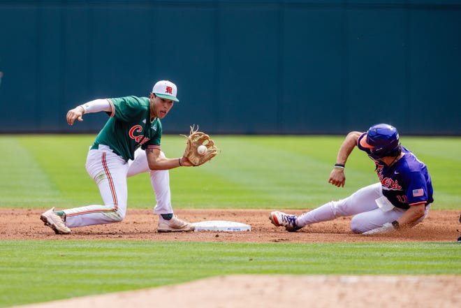 May 23, 2024; Charlotte, NC, USA; Clemson Tigers utility Jimmy Obertop (11) slides safely into second against Miami (FL) Hurricanes infielder Antonio Jimenez (13) for a stolen base during the ACC Baseball Tournament at Truist Field. Mandatory Credit: Scott Kinser-USA TODAY Sports