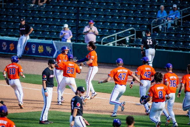 May 24, 2024; Charlotte, NC, USA; Clemson Tigers utility Jimmy Obertop (11) is rushed after a walk off walk to defeat the Louisville Cardinals during the ACC Baseball Tournament at Truist Field. Mandatory Credit: Scott Kinser-USA TODAY Sports