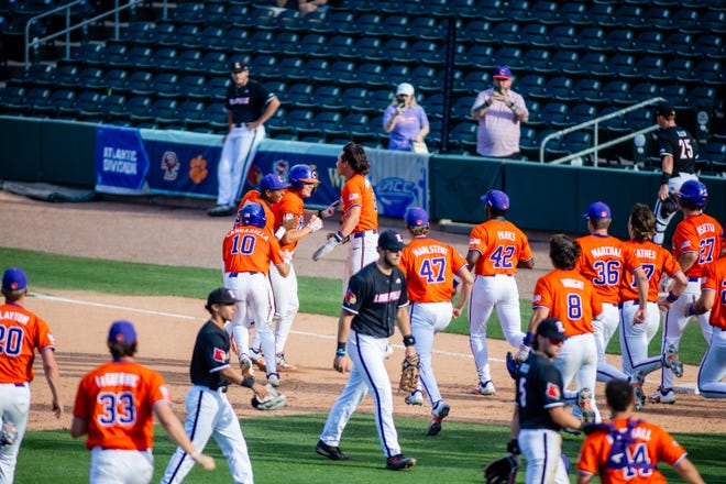 May 24, 2024; Charlotte, NC, USA; Clemson Tigers utility Jimmy Obertop (11) is rushed after a walk off walk to defeat the Louisville Cardinals during the ACC Baseball Tournament at Truist Field. Mandatory Credit: Scott Kinser-USA TODAY Sports