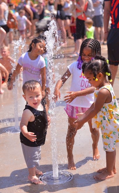 Unity Park held its grand opening on downtown Greenville's west side, Thursday morning, May 19, 2022. The new 60-acre park, nearly two years under construction, completes the "necklace of parks" surrounding downtown. The park "pays homage to the legacies of the neighborhoods surrounding it" and will include affordable housing opportunities. Children, including Cameron Martinez, 1, left, and Skylar Fleming, 2, right, enjoy the new water park feature.