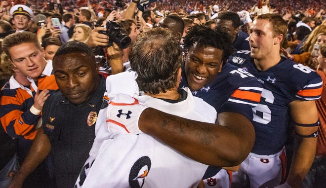 Auburn head coach Gus Malzahn hugs Auburn offensive lineman Kamaar Bell (79) in the Iron Bowl at Jordan-Hare Stadium in Auburn, Ala., on Saturday, November 30, 2019.